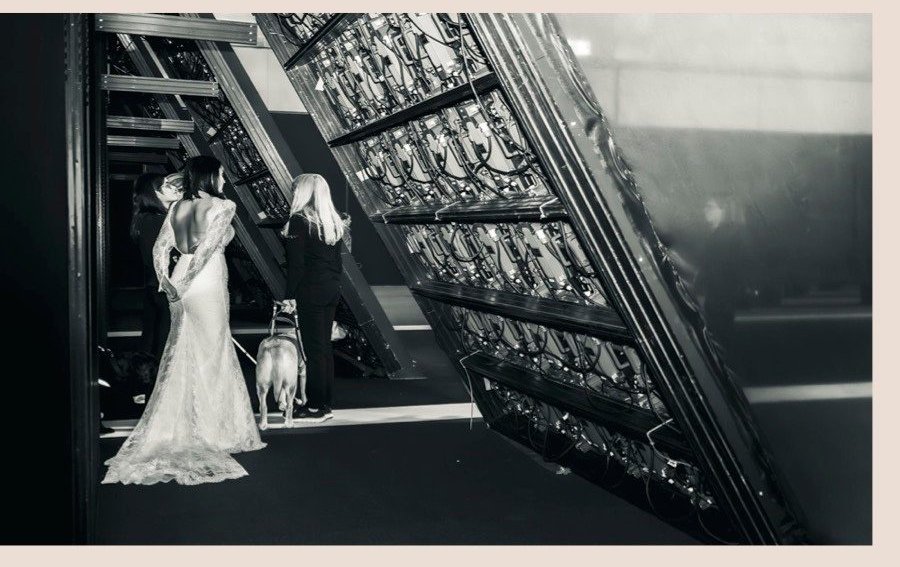 Backstage in bianco e nero: modella in abito da sposa con cane guida